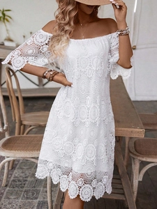 Dettaglio dei motivi in pizzo bianco e delle maniche a campana del vestito con spalle scoperte