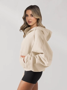 Detail of oversized cream hoodie featuring dropped shoulders and soft cotton texture