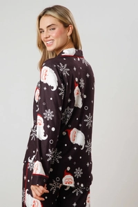Detail of Christmas pajama set featuring Santa print and red piping on soft fabric