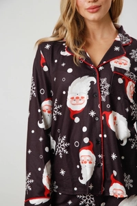 Detail of Christmas pajamas featuring Santa Claus prints and red piping on the lapel