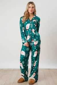 Detail of Christmas pajamas set featuring Santa Claus prints and red piping on dark green fabric