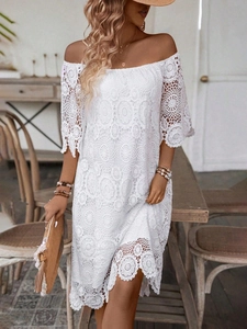 Dettaglio dell'abito in pizzo crochet bianco con spalle scoperte e fiori boho