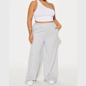 Close-up of high-waist grey wide-leg yoga pants with elastic waistband and side pockets