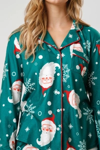 Detail of Christmas pajamas featuring Santa Claus prints and red piping on green fabric