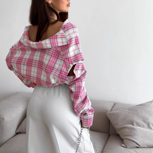 Rosafarbene karierte Langarmbluse kombiniert mit einer weißen weiten Hose am Modell
