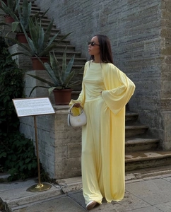 Detail of light yellow three-piece set with long cardigan and wide-leg trousers