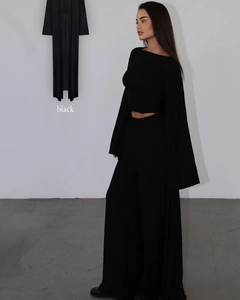 Detailed view of women's black three-piece set with cardigan top and wide-leg trousers