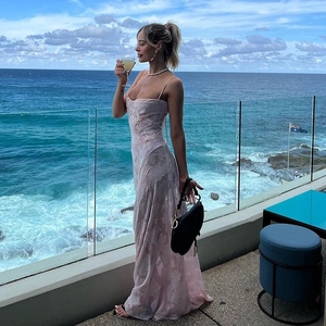 Detail of pink strapless maxi dress with jacquard floral pattern on a seaside terrace