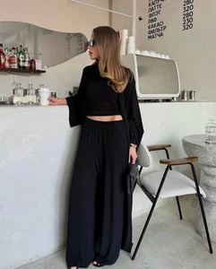 Chic black three-piece set with a long cardigan, cropped top, and high-waist wide-leg pants
