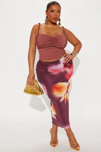 Detail of ruched camisole top with braided straps and floral print high-waisted maxi skirt