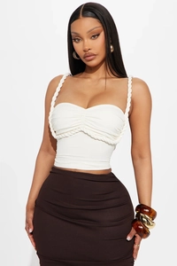 Detail of white sleeveless top with braided rope straps and pleated bust design