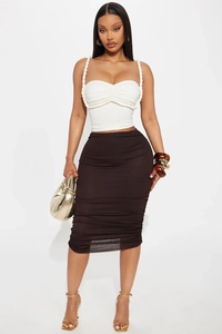 Detail of white cropped tube top with woven rope straps and ruched brown mini skirt