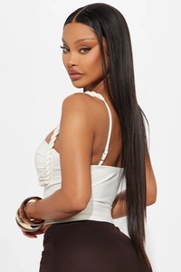Detail view of white corset top featuring thick braided rope straps and textured fabric