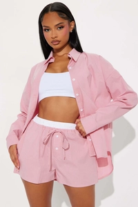 Close-up detail of pink striped button-down shirt and matching drawstring shorts