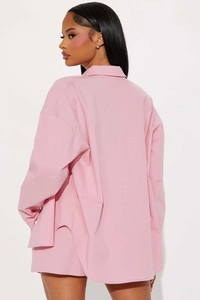 Detail view of pink long sleeve shirt with vertical stripes and curved side split hem
