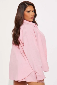 Detail view of pink button-down shirt with fine vertical texture and classic collar