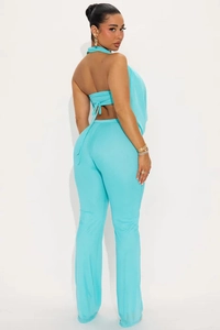 Détail du haut court dos nu bleu canard et du pantalon évasé à taille haute assorti