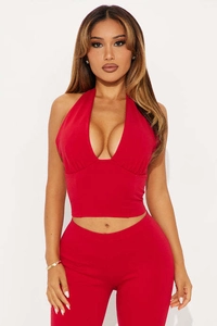 Detail view of red halter-neck top with deep V-neckline and matching slim-fit pants