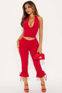 Detail of red halter V-neck top and cropped flared pants with ruffled lace-up cuffs