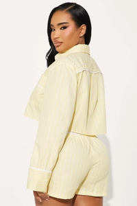 Detail of yellow and white striped cropped shirt and high-waisted shorts set
