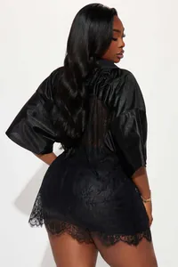 Detail of sheer lace patchwork and embroidery on the back of black satin short sleeve top