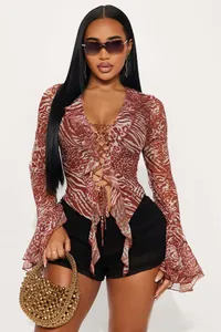 Detail of V-neck lace-up animal print top with flared sleeves and stylish ruffles