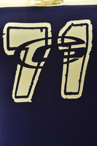 Close-up detail of dark blue fabric featuring a vintage yellow 71 print and white drawstring