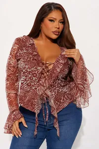 Detail of ruffle trim and lace-up V-neckline on animal print long sleeve top