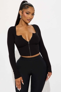 Detail of black ribbed V-neck zip-up top with notched neckline and fitted long sleeves