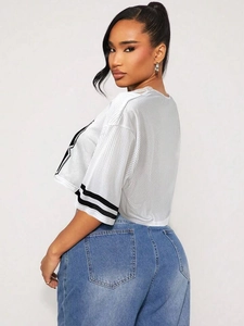 Détail du tissu du crop top en maille blanche avec doubles rayures noires aux poignets