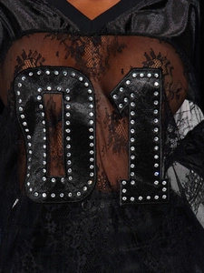 Close-up of black lace t-shirt featuring sparkling rhinestone number 01 patch detail