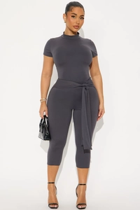 Détail d'un ensemble gris foncé moulant avec haut à col montant, ceinture nouée et legging