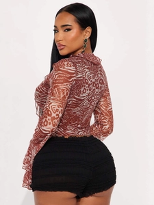 Women's animal print mesh top with ruffles and matching pleated black shorts