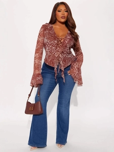 Women's animal print tie-front ruffle top paired with blue flare jeans for a chic autumn look
