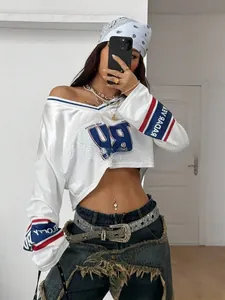 Detail eines sportlichen weißen V-Ausschnitt Crop Tops mit rot-blauen Streifen