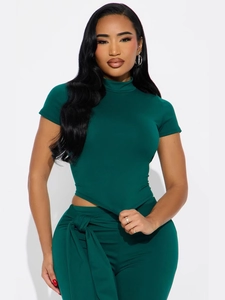 Ensemble chic deux pièces vert foncé avec haut à col montant et pantalon à ceinture nouée