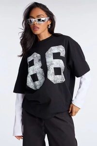 Detail of the oversized 86 graphic print on layered black and white long sleeve tee