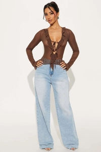 Dettaglio del top in mesh marrone con scollo a V a balze e allacciatura sul davanti