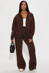 Detail of a dark brown tracksuit with zipper jacket and high waist wide leg pants for women