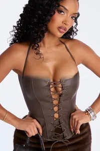 Close-up of lace-up faux leather corset top with metallic rivets and halter neck detail