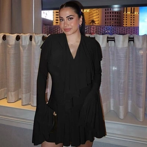 Close-up of deep V-neck and ruffle details on elegant black slim fit long sleeve dress