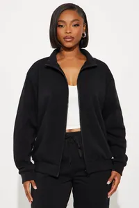 Close-up of black stand-collar zipper sweatshirt and matching drawstring jogger set