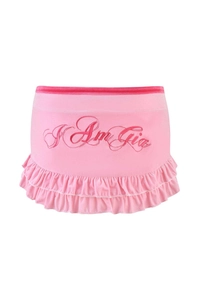 Detail of pink ruffled mini skirt with artistic text embroidery and soft velvet texture
