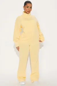Detail view of light yellow two-piece tracksuit with stand collar zip-up jacket and pants