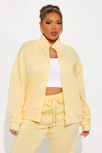 Full body view of a women's pale yellow tracksuit with zip jacket and drawstring pants