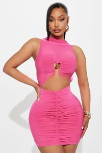 Détails de la mini robe moulante rose avec fronces et décor en métal de cœur