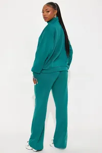 Side view detail of a dark green two-piece tracksuit with high neck and long pants