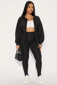 Détail d'un ensemble survêtement noir avec sweat à capuche zippé et legging de sport