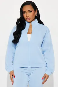 Detail of light blue tracksuit showing stand collar zipper and ribbed cuffs for women