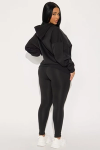 Vue latérale de legging de yoga taille haute et sweat à capuche noir à épaules tombantes